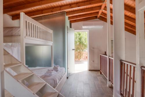 a bedroom with two bunk beds and a staircase at Sahara Blanc Villa - Private Pool - Loft Space in Spiliazéza