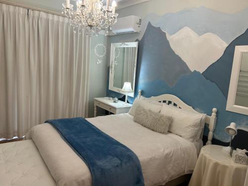 a bedroom with a large bed with a blue wall at Bonne Esperance in Tyger Valley