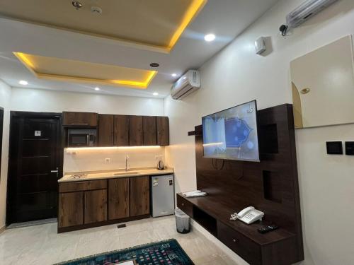 a kitchen with a sink and a tv on the wall at منتصف البيعة للشقق المخدومة in Taif