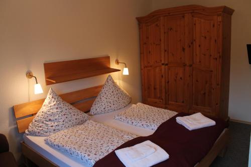 a bedroom with two beds and a wooden cabinet at Leezdorfer Hof in Leezdorf