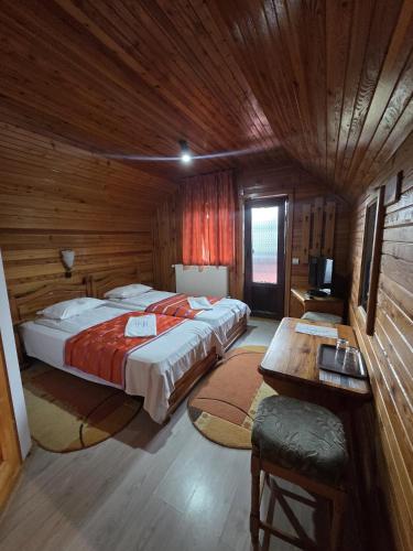 a bedroom with a large bed in a wooden cabin at Casa Elena - Resort & SPA in Voronet