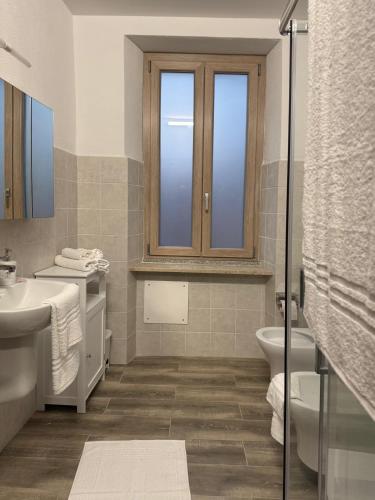 a bathroom with a toilet and a sink and a window at La Funtanella in Aggius
