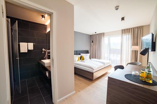 a hotel room with a bed and a bathroom at Hotel Garni Maximilian in Dingolfing