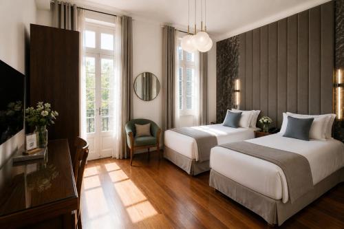 a hotel room with two beds and a mirror at Duque Hotel Boutique & Spa in Buenos Aires