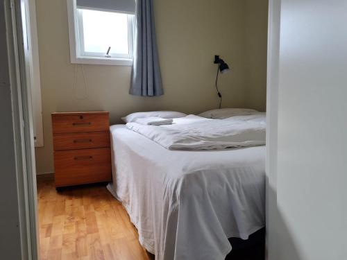 a bedroom with a bed and a dresser and a window at Modern Arctic Apartment in Tromsø