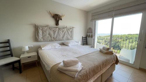 a bedroom with a bed and a large window at Casa Loto in Pals