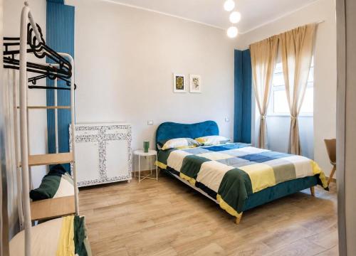 a bedroom with a blue and white bed and a ladder at Fuoribinario B&B in San Felice a Cancello