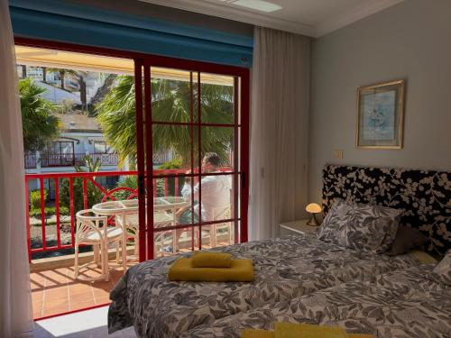 a bedroom with a bed and a balcony with a table at Playa del Cura - Beachside Retreat in Playa del Cura