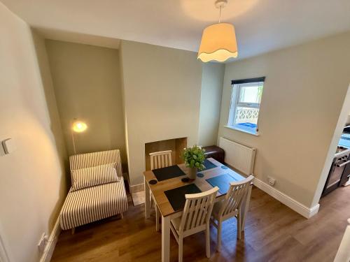 a living room with a dining room table and a chair at Salisbury City Centre Cottage in Salisbury