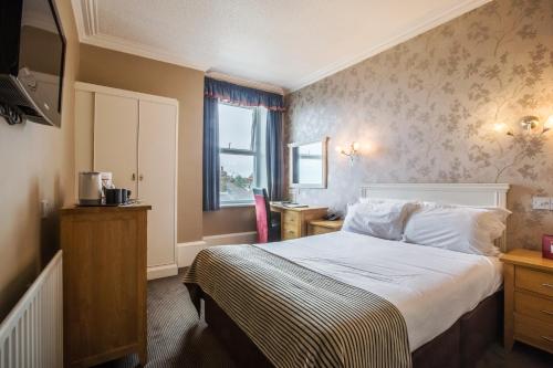 a hotel room with a bed and a television at Muthu Westcliff Hotel (Near London Southend Airport) in Southend-on-Sea
