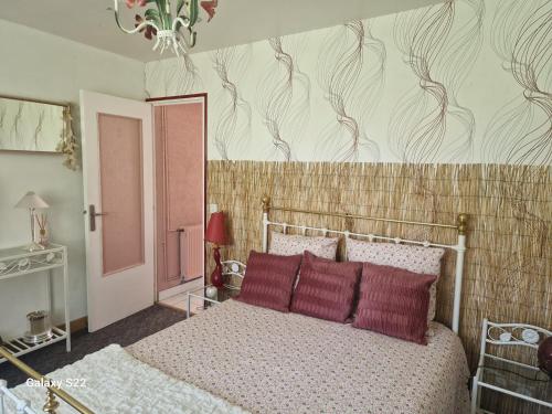 a bedroom with a bed with red pillows on it at Maison de campagne à Balaives et Butz in Flize
