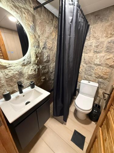 a bathroom with a sink and a toilet and a mirror at Beel Hills in Khallat al Mutayn