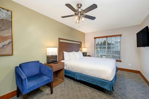 a bedroom with a bed and a blue chair at WorldMark Blaine in Birch Bay