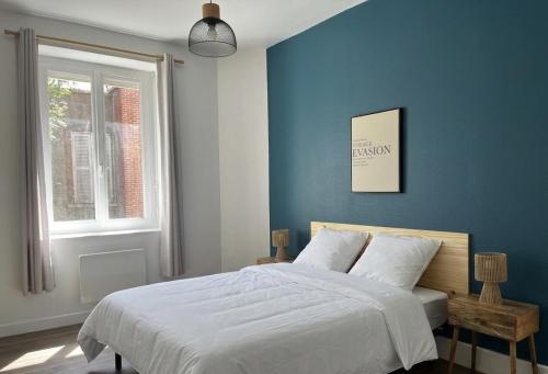 a bedroom with a bed with a blue wall at La maisonnette 70' in Groseillier