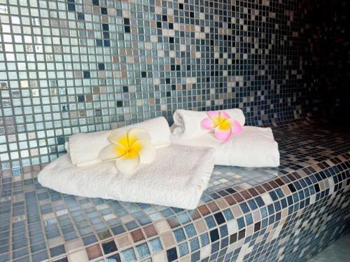 two towels with flowers on them sitting on a bed at Chalet 26 Widemouth Bay in Bude