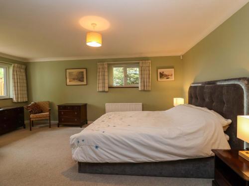 a bedroom with a large bed and a chair at Meadowcroft in Watchet