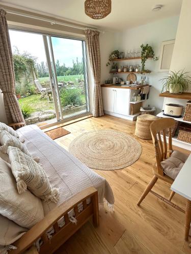 a bedroom with a bed and a large window at Sunset View - Luxury accommodation in the Cotswolds in Tewkesbury