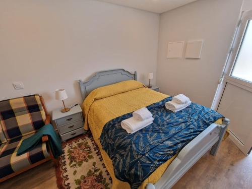 a bedroom with a bed with two towels on it at 4 Seasons studio in Marinha das Ondas