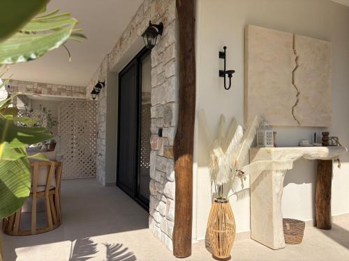 a hallway with a stone wall and a vase at Noima Kalamitsi Boutique Studios in Kalamitsi