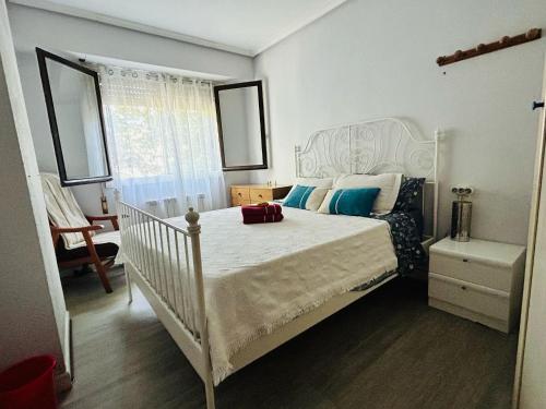 a bedroom with a white bed and a chair at Espaciosa y Luminosa in San Sebastián