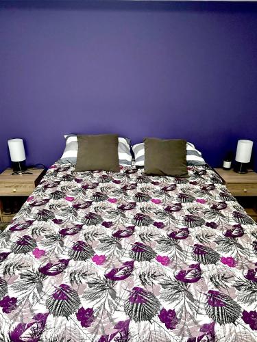 a bedroom with a bed with a purple wall at Departamento Independiente a 2 cuadras de Costanera in Punta Arenas
