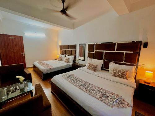 a hotel room with two beds and a couch at Hotel Ambience Hill Nainital - near Bhowali in Nainital