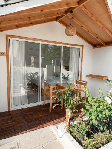 a patio with a table and a glass door at Boli Dhigurah in Dhigurah