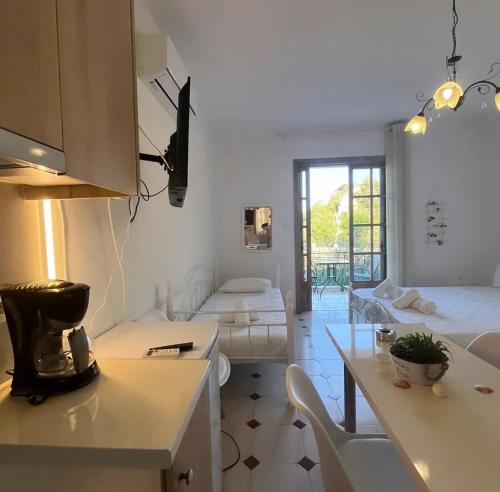 a room with a kitchen and a living room at Petros Studios in Nea Epidavros