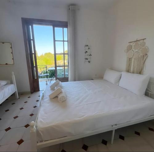 a large white bed in a room with a window at Petros Studios in Nea Epidavros