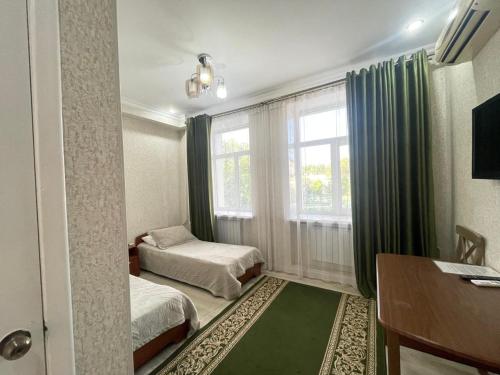 a small room with two beds and a window at Жастар in Astana