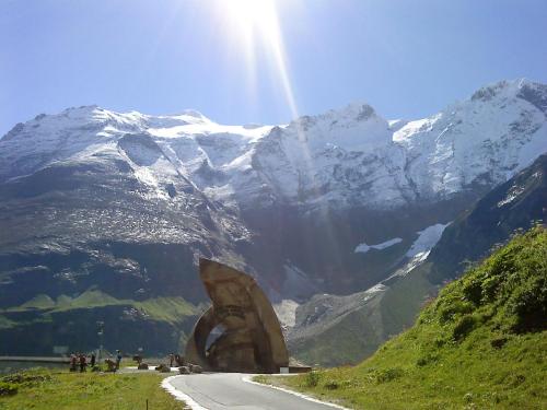 a road with a large sculpture on the side of a mountain at Biobauernhof Kleinummerstall in Mittersill