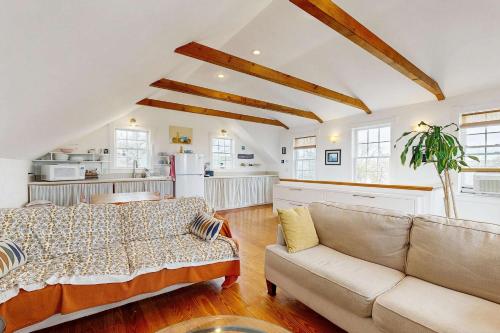 a living room with a couch and a kitchen at Charming cottage close to the beach in Truro