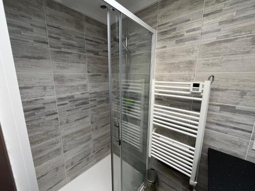 a shower with a glass door in a bathroom at LES COTTAGES DE LEON in Léon