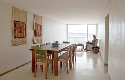 ein Esszimmer mit einem Tisch, Stühlen und einer Frau in der Unterkunft Oceano Patagonia in Puerto Pirámides