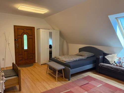a living room with a bed and a couch at Ubytovanie pri lese a vode in Hamuliakovo