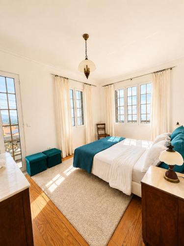 a bedroom with a large bed and a large window at A Velha Casa Caboz in Ponta do Sol