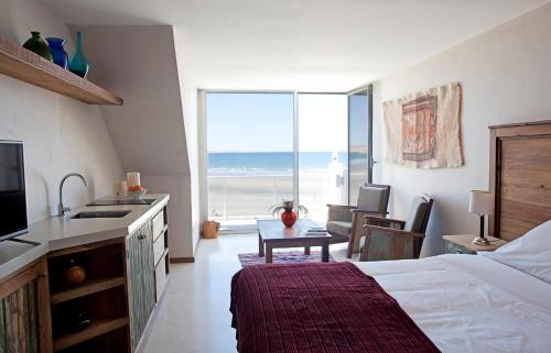sypialnia z łóżkiem oraz kuchnia z widokiem na ocean w obiekcie Oceano Patagonia by Nordic w mieście Puerto Pirámides