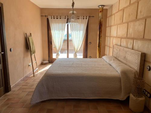 a bedroom with a bed and a large window at Ca Na Marina in Cala Llombards
