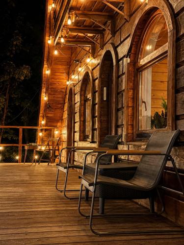 a deck with chairs and lights on a building at Forest Camp Dom w Górach Sowich in Michałkowa