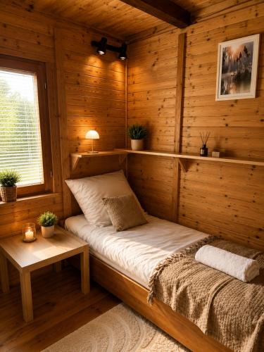 a room with a bed in a wooden cabin at Argentum Luxury Bungalov in Gąbin