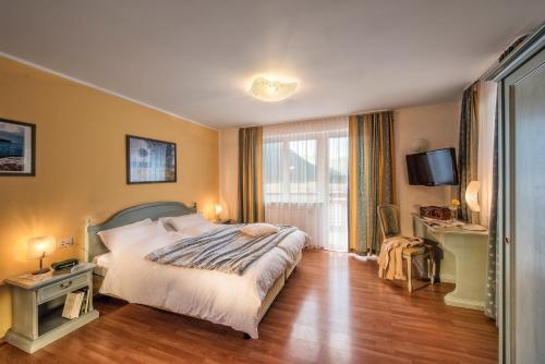 a bedroom with a large bed and a television at Hotel Bad Salomonsbrunn in Anterselva di Mezzo