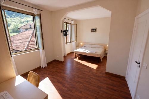 a bedroom with a bed and a large window at Hotel Degli Angeli in Pontinvrea