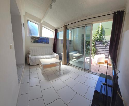 a living room with a couch and a table at maison cosy pour 4 à 5 personnes 10mns des plages in Sanary-sur-Mer