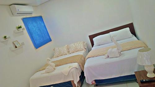 a bedroom with two beds and a blue window at Hospedaje Alexa in Asunción