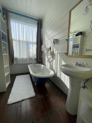 a bathroom with a tub and a sink and a mirror at B-Love's Guest House in Oakland