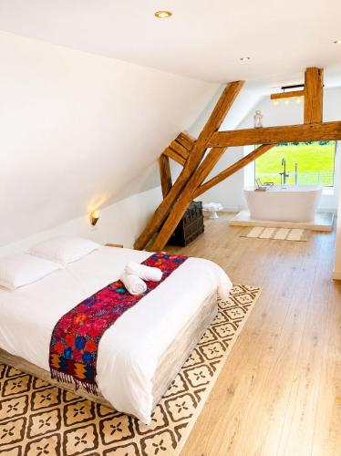 a bedroom with a bed and a bath room at Domaine la Héroïca in Maisonnais