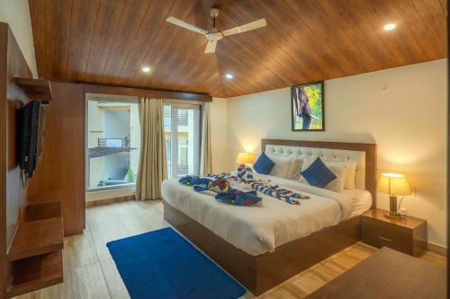a bedroom with a large bed with two people on it at Mango Bloom River Resort By Excel Hotels & Resorts in Marchula