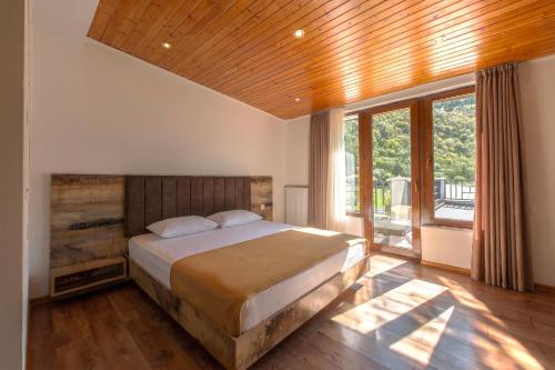 a bedroom with a bed and a large window at Anne's Hotel in Mestia in Mestia