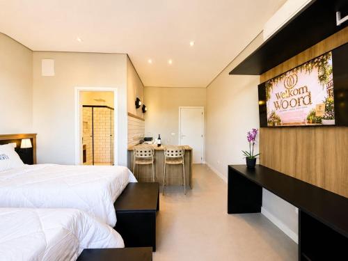 a hotel room with two beds and a kitchen at Welkom Woord - Aluguel Flats e Aptos curta temporada - Entrada com senha in Holambra