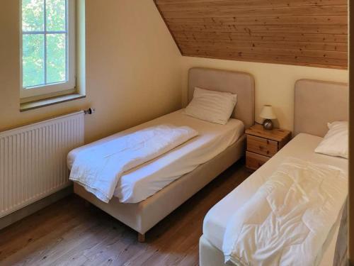 a bedroom with two beds and a window at Landhuis Schneifel in Brandscheid